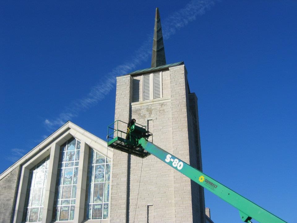 Pressure washing the exterior of a church to remove dirt and restore its appearance.