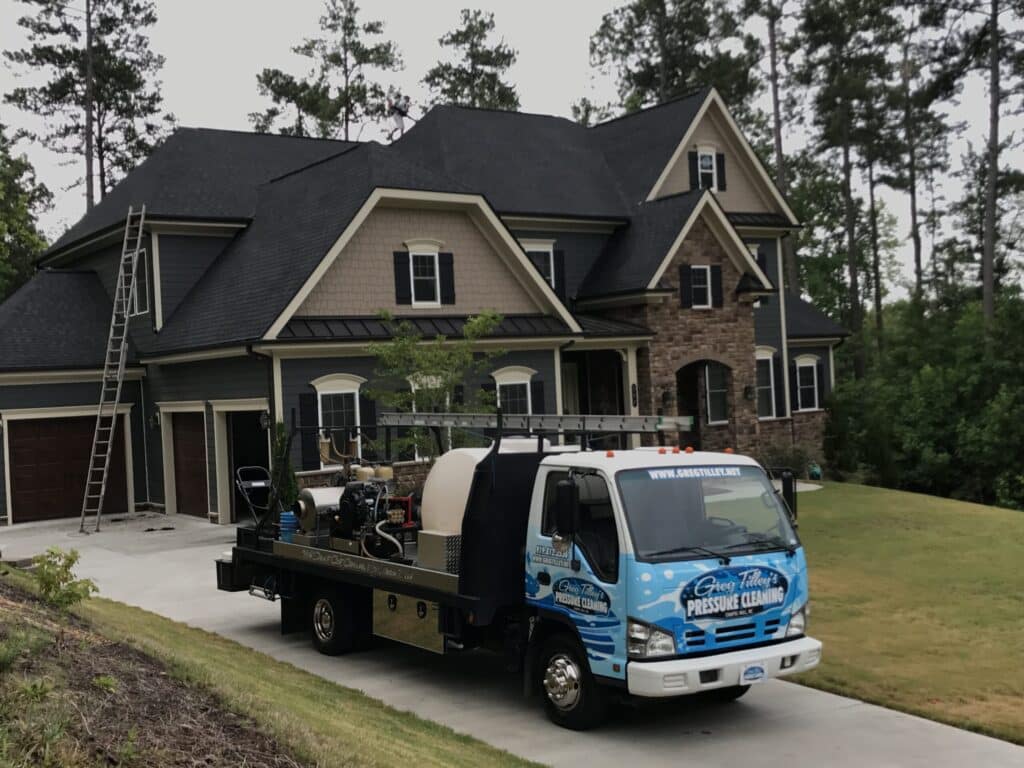 Pressure washing a large residential property to remove dirt, grime, and stains.
