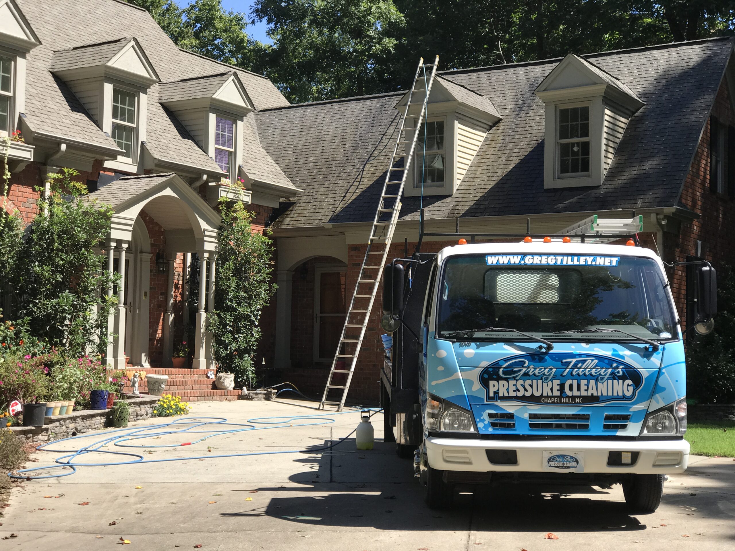 Pressure washing a large residential property to restore its clean appearance and remove dirt and stains.