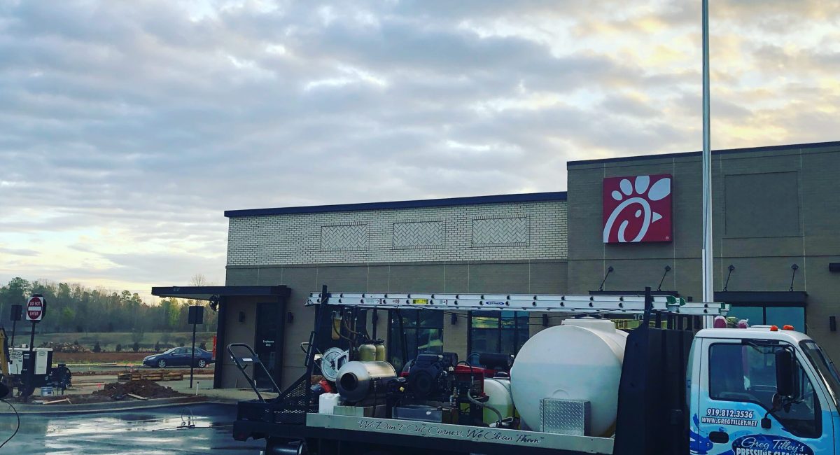 Pressure washing the exterior of a Chick-fil-A restaurant to remove dirt and grime.