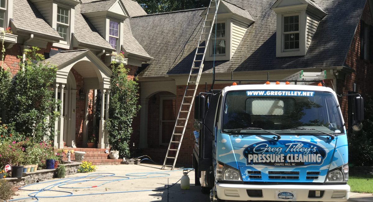 Pressure washing a large residential property to restore its clean appearance and remove dirt and stains.